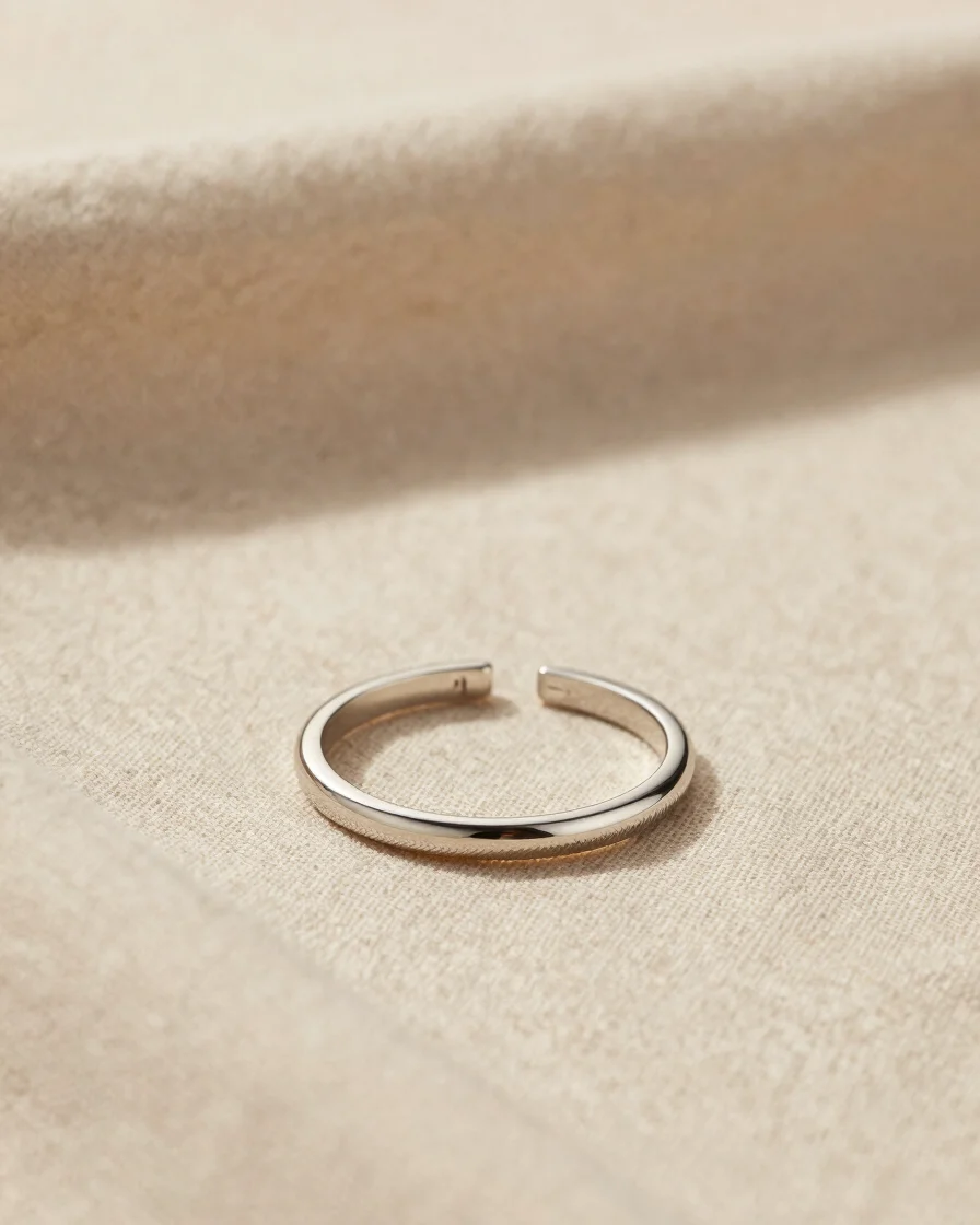 Warm editorial studio photography of fine stainless steel jewelry