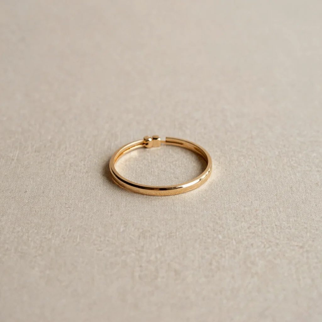 Bague galbée posée sur un tissu neutre, profondeur de champ subtile, 85mm